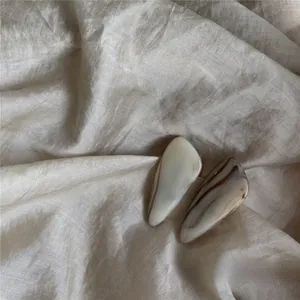Detailed close-up of marble-patterned hair clips on a textured beige fabric background
