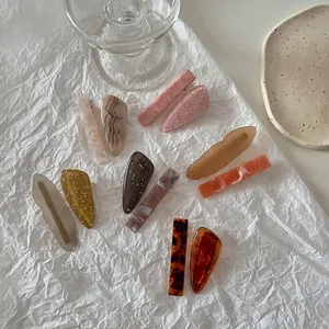Elegant collection of 11 amber and pink marble acrylic hair clips in various shapes