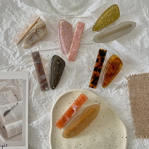 Detail of assorted resin hair clips featuring gold foil flakes and amber textures