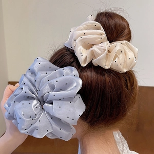 Chouchous en organza à pois crème et bleu présentés sur une coiffure en chignon