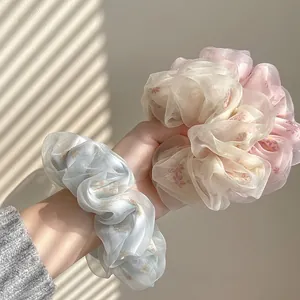 Detail of floral organza scrunchies in blue and beige with elegant shadows