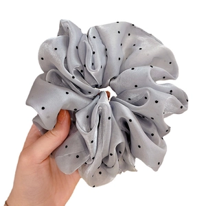 Chouchou à pois gris clair en mousseline avec points noirs sur fond blanc épuré