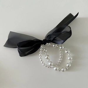 Elegant double-layered black chiffon bow hair tie with layered pearl beads on a grey base