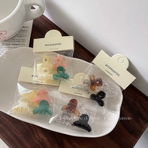Set of mini jelly color bow hair claws in multiple colors on a ceramic plate