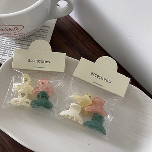 Close-up of four jelly-colored mini bow hair clips in premium transparent bag packaging