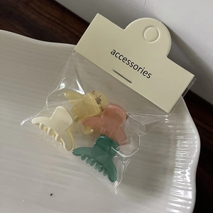 Set of four jelly color mini hair claws in cream, yellow, pink, and green on display card
