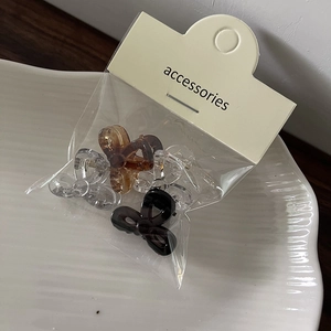 Close-up of 4pcs mini jelly color bow hair clips in transparent plastic packaging