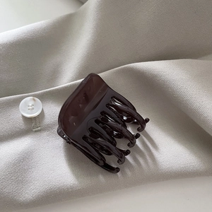 Vue détaillée d'une pince à cheveux écaille de tortue sur un tissu texturé neutre