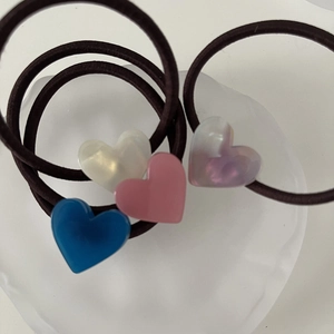 Set of four jelly-colored heart hair ties in white, pink, purple, and blue colors