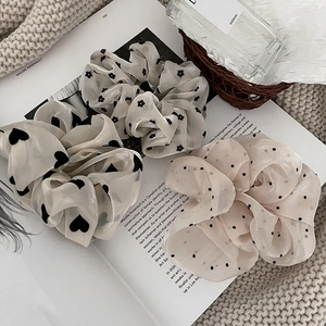 Haargummis aus Mesh-Spitze mit Punkten und Blumen auf einem Magazin im französischen Stil