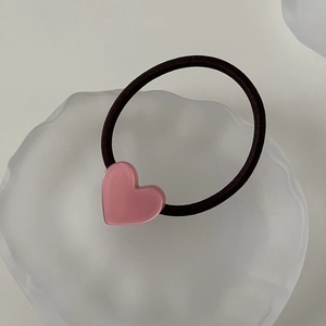 Close-up of pink acetate heart charm on a black high-elastic hair tie for daily wear