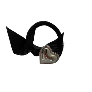 Elastico per capelli nero con fiocco in nastro e ciondolo a cuore argento su fondo bianco