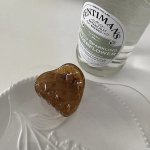 Elegant amber heart hair claw with quilted texture on white ceramic plate