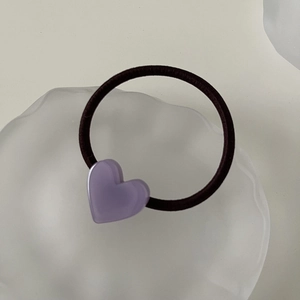 Detailed macro view of a lavender heart resin hair tie on a frosted aesthetic tray