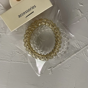 Dettaglio degli elastici per capelli a spirale ambra e trasparenti su carta originale