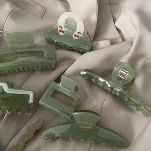 Acetate hair clips set featuring green checkerboard patterns and cherry rhinestone accents