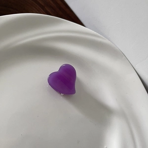 Detail of a purple translucent heart hair claw clip with a marble acetate pattern