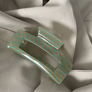 Close-up of green checkerboard acetate hair claw clip with Barrette à France text detail