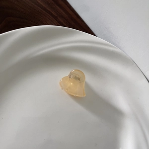 Detailed close-up of a heart-shaped mini hair claw in translucent amber finish
