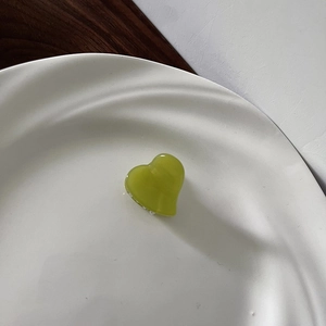 Macro shot of a heart-shaped grass green acetate hair claw with jelly-like glossy finish