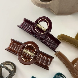 Macro detail of glossy shark hair clips with durable gold springs in earth tones
