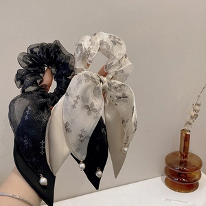 Close-up of bow hair scrunchies in black and white organza with delicate pearl charms