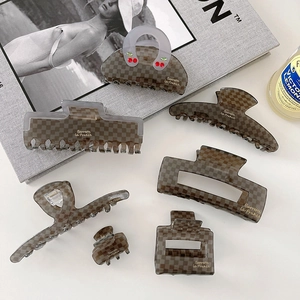 Flat lay of brown checkerboard acetate hair clip set with cherry detail and magazine