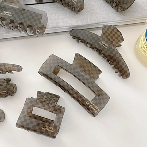 Detail view of acetate checkered hair clips with Barrette La France gold lettering