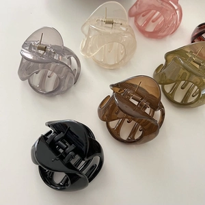 Detailed view of six colorful jelly resin hair claws in black, brown, and pastel tones