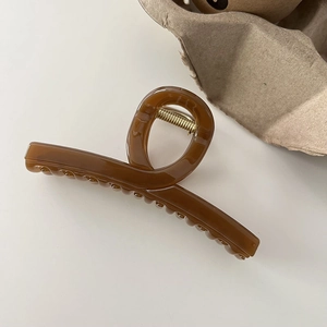 Detailed view of a large brown resin shark hair clip with a minimalist twist design