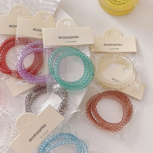 Colorful spiral phone cord hair ties set in minimalist packaging with accessories label