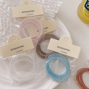Set of colorful spiral hair ties in clear phone cord style with pastel packaging