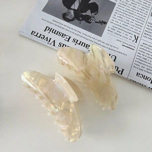 Detail of France Handmade acetate hair claw clip with pearlescent white marble finish
