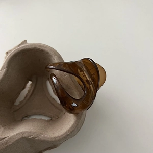 Close-up of translucent amber hair claw clip with modern hollowed-out streamlined design
