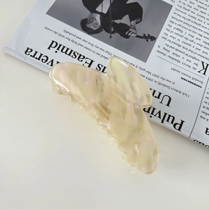 Close-up of pearlized beige butterfly hair claw with Handmade France engraving on inner side