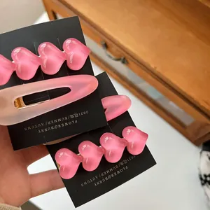 Nahaufnahme der rosa Herzperlen-Clips und matten Haarnadeln auf der Displaykarte