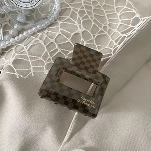 Detail showing the vintage checkerboard pattern and Barrette La France gold text on hair claw