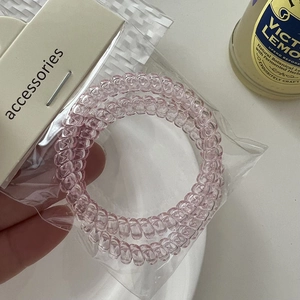 Close-up of translucent pink spiral telephone wire hair ties in retail packaging