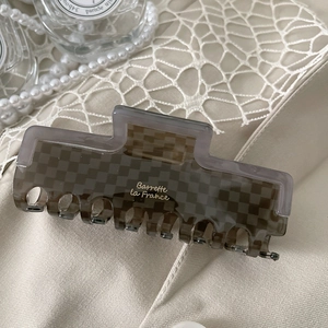 Detail of dark brown checkerboard hair claw clip with Barrette la France logo lettering