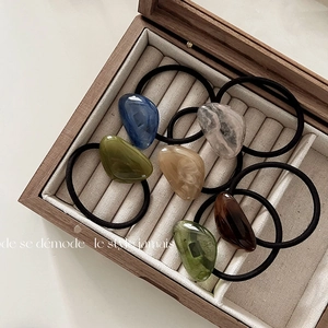 Detailed close-up of 6 minimalist acrylic pea-shaped hair ties in diverse colors and textures