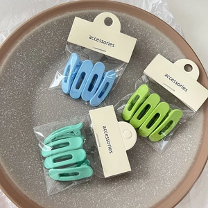 Détails d'un lot de pinces à cheveux en plastique mat bleu et vert avec emballage carte
