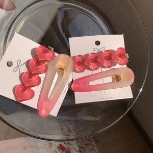 Details von rosa herzförmigen Haarspangen aus Harz auf einem Glastablett präsentiert