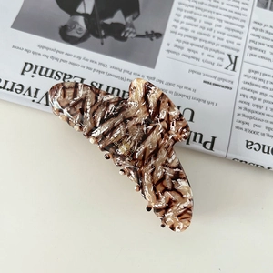 Detail of a handmade butterfly tortoise shell acetate hair claw with marble texture