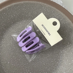 Vue détaillée de quatre pinces à cheveux violettes mates dans leur emballage de vente