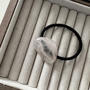 Detail of a pink irregular resin stone on a black elastic hair tie for women