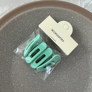 Lot de quatre barrettes à cheveux vert menthe mat dans un emballage minimaliste