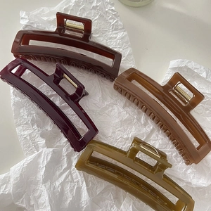 Close-up of four glossy rectangular hair claws in coffee, burgundy, caramel, and olive green