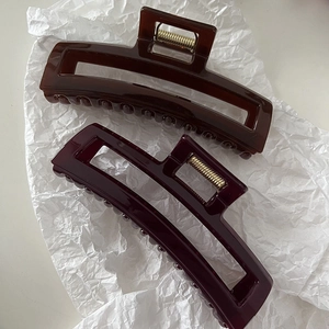 Detail view of large rectangular hollow hair claws in coffee and burgundy acrylic