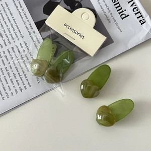 Détail de deux pinces à cheveux coeur vert gelée sur carte sur un magazine mode