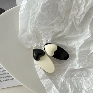 Barrettes à cheveux minimalistes coeur noir et blanc avec finition brillante sur fond chic